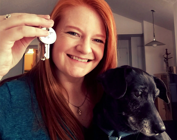 Picture of Christine Koch from California with her pup holding up keys to her new home.