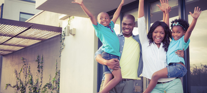 Black family with hands in air excited about new home purchase.